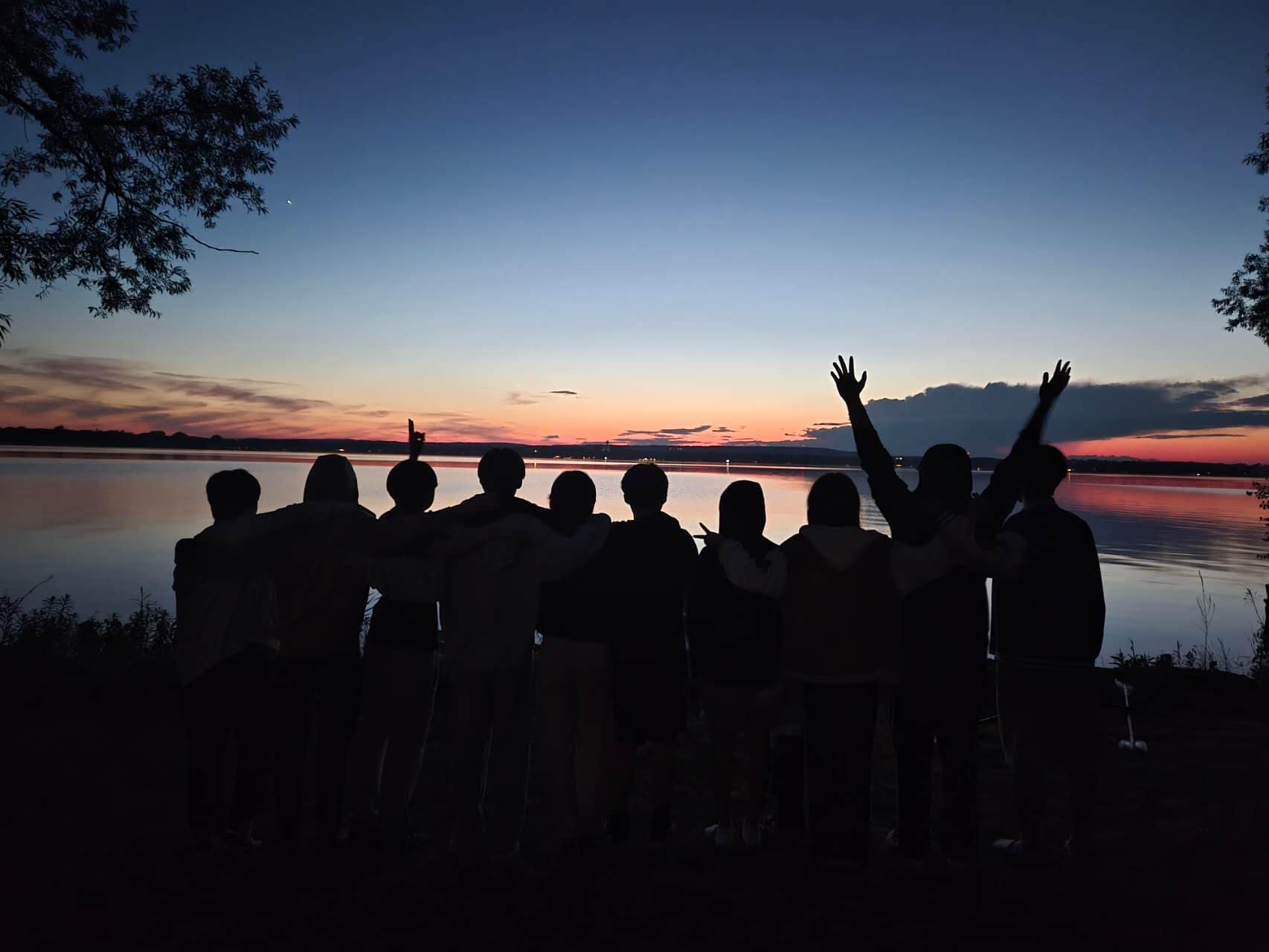 Friends posing in front of a sunset